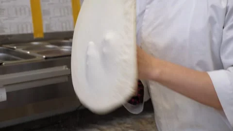 Skilled chef preparing dough for pizza rolling with hands and throwing up. Stock Footage 307388357