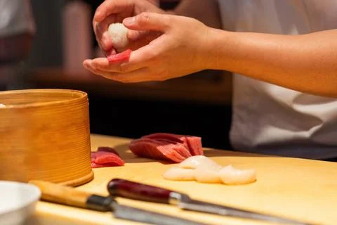 Skilled chef preparing sushi with fresh ingredients and bamboo steamer Stock Photos