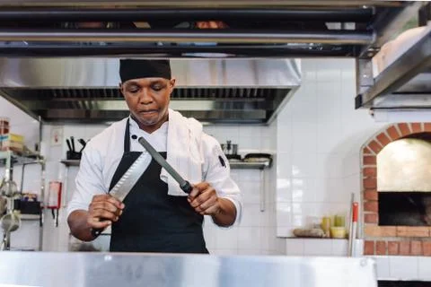 Skilled chef sharpening his Knife Stock Photos