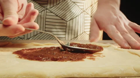 Skilled chef swiftly covers dough with flavorful tomato paste by spoon Stock Footage 331846826