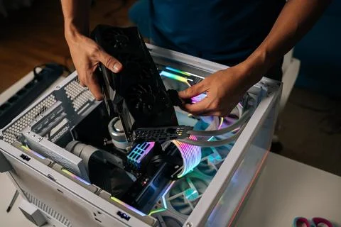Skilled computer professional inserting high-performance graphics card into Stock Photos