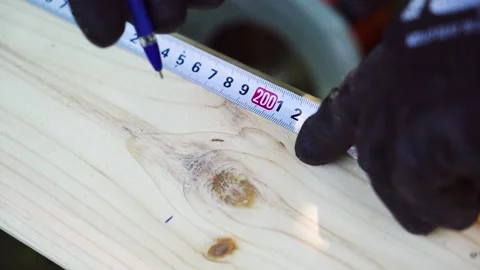 Skilled Construction Worker Measuring Wood for Accuracy Stock Footage 247853087