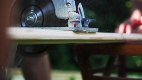 Skilled Construction Worker Operating Circular Saw on Wooden Board Stock Footage 248227600