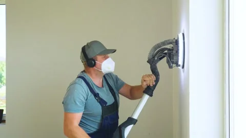 Skilled construction worker works indoors. Man smooths plastered wall using Stock Footage 319210891