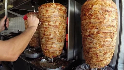 Skilled Cook Sharpening Knife In Front Of Rotating Spit Stock Footage 93896674