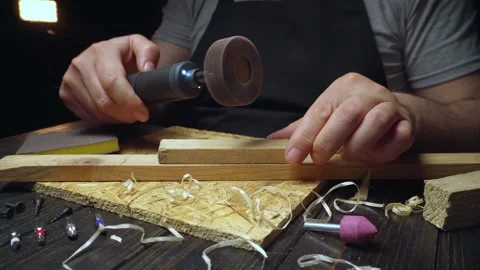 Skilled craftsman uses rotary tool with sanding drum on wooden plank, surrounded Stock Footage 335549704