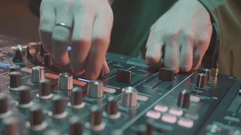 Skilled DJ pulls levels and turns vinyl on modern turntable Stock Footage 268422846