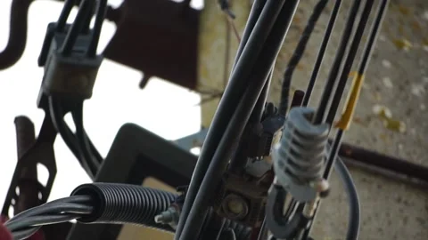 Skilled electrician fixes wires standing on ladder near high pole against blue Stock Footage 280107627
