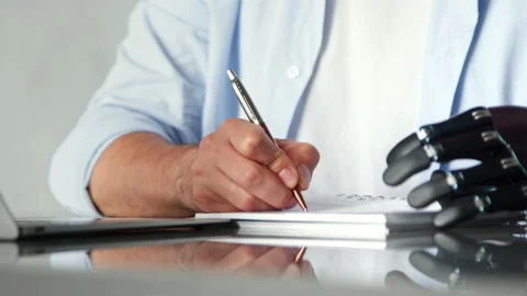 Skilled employee man with artificial hand writes orders Stock Footage 157347849