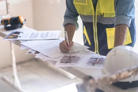 Skilled engineer editing project drawings on construction equipment in Stock Photos
