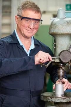 Skilled Engineer Using Drill In Factory Stock Photos