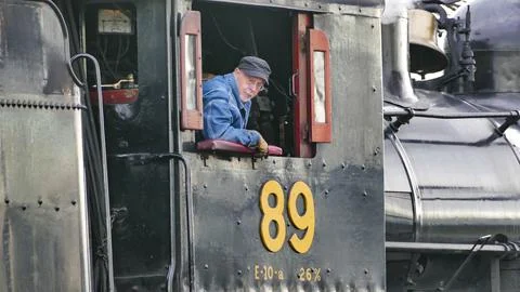 Skilled engineer works on steam engine controls at a historic railway stati.. Foto stock