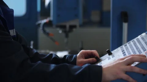 Skilled factory worker operates drill machine using control panel in workshop. Stock Footage 313815274