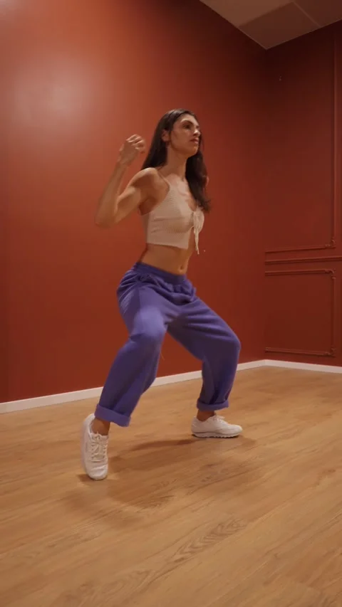 Skilled female dancer training with a rhythmic and fluid hip-hop style. Stock Footage 312515011