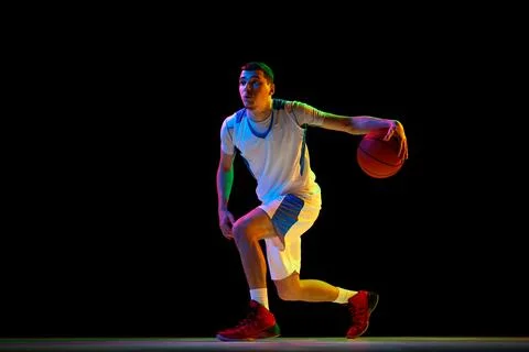 Skilled, focused basketball player performs combined ball-handling technique Photos