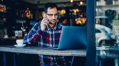 Skilled freelancer in spectacles making booking Stock Photos