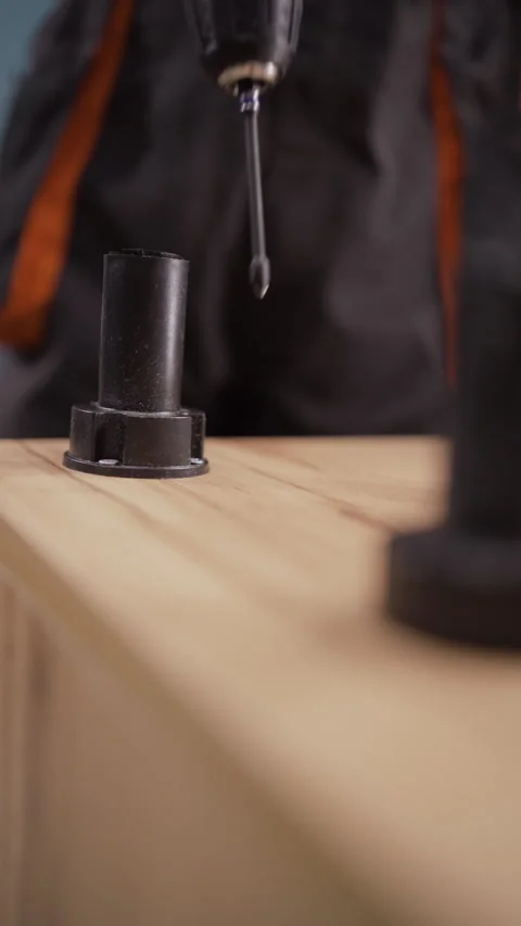 Skilled furniture assembler in uniform completing the assembly process of a Stock Footage 310374427
