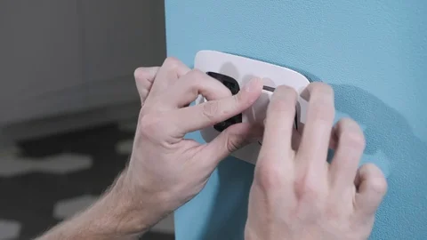 Skilled handyman fixes light switch in frame close view Stock-Footage 106377066