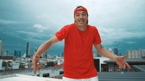 Skilled hipster looking at camera while standing at sky scrapper view. Hiphop. Stock Photos