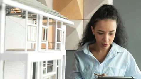 Skilled hispanic engineer using tablet analysis house structure. Manipulator. Stock Photos