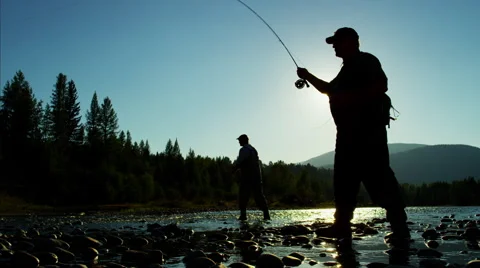 Skilled hobby fisherman in silhouette casting line for freshwater fishing Stock Footage