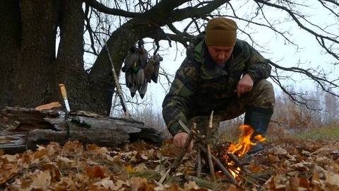 Skilled hunter has a rest at a fire Video stock 100631419