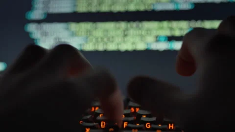 A skilled IT engineer rapidly types complex algorithms on the keyboard enhan Stock Footage 331866677