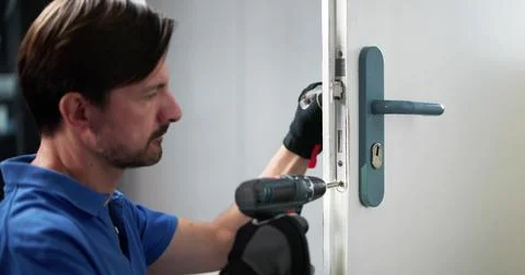 Skilled Locksmith Carefully Installing New Lock On Customer's Front Door. A P Stock Photos