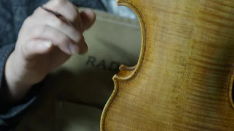 Skilled luthier applying protective varnish layer, hand crafting vintage st.. Stock Photos