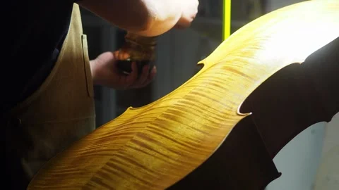 Skilled luthier brushing varnish onto cello back plate marbling, preserving.. 스톡 동영상 313289836
