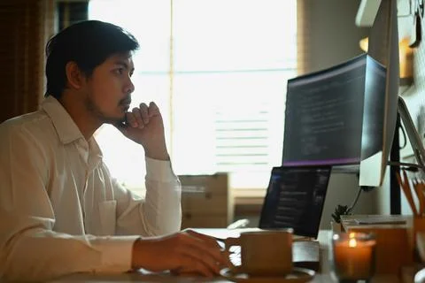 Skilled male software developer programming code on the computer for cyber Stock Photos