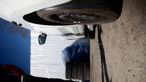 Skilled man car mechanic replace tire on wheel in auto repair service outside. Stock Footage 115567065