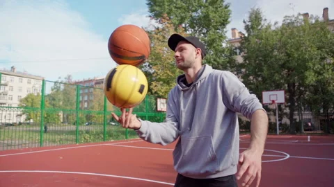 Skilled man doing trick spinning two basketballs on finger 스톡 동영상 163060165
