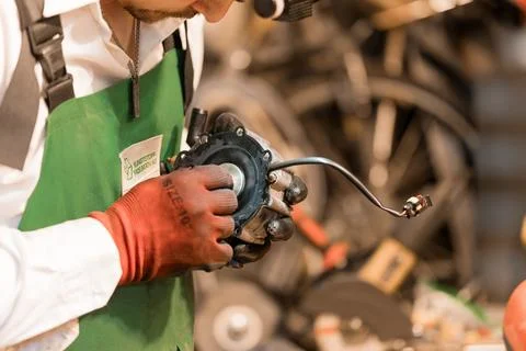 Skilled Mechanic Performing Precision Work on Engine Component in Workshop 스톡 사진