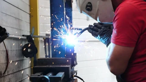 Skilled mechanic performing welding in an auto service workshop, sparks Video stock 318726216