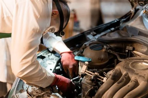 Skilled Mechanic Working on Car Engine with Precision and Focus 写真素材