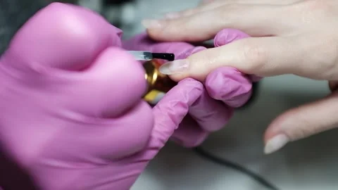 Skilled nail technician applying nail polish or base coat, making a manicure. Stock Footage 326251686