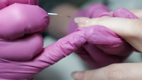 Skilled nail technician applying nail polish or base coat, making a manicure. Stock Footage 326251950