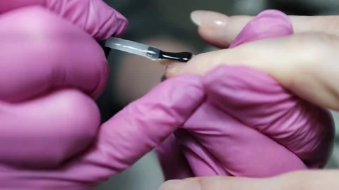 Skilled nail technician applying nail polish or base coat, making a manicure. 库存影片 326251954