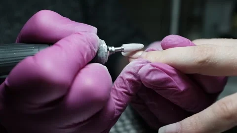Skilled nail technician using electric manicure drill to remove gel coating Stock Footage 326252067