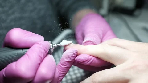 Skilled nail technician using electric manicure drill to remove gel coating Stock Footage 326252159