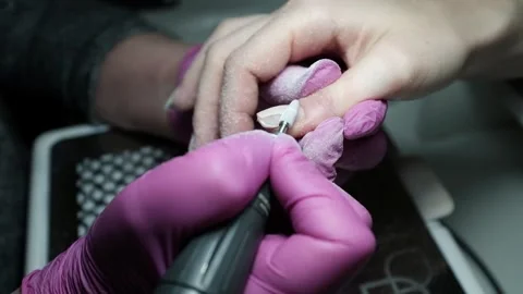 Skilled nail technician using electric manicure drill to remove gel coating Video stock 326252351