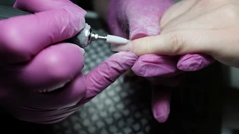 Skilled nail technician using electric manicure drill to remove gel coating Stock Footage 326252488