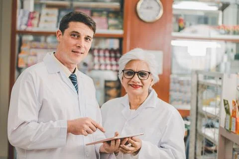 Skilled pharmacist is consulting, analyzing the use of drugs to recommend a.. Stock Photos