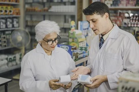 Skilled pharmacist is consulting, analyzing the use of drugs to recommend a.. Stock Photos