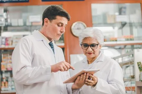 Skilled pharmacist is consulting, analyzing the use of drugs to recommend a.. Stock Photos
