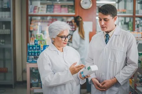 Skilled pharmacist is consulting, analyzing the use of drugs to recommend a.. Stock Photos