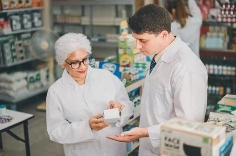 Skilled pharmacist is consulting, analyzing the use of drugs to recommend a.. Stock Photos