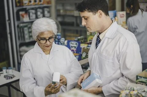 Skilled pharmacist is consulting, analyzing the use of drugs to recommend a.. Stock Photos