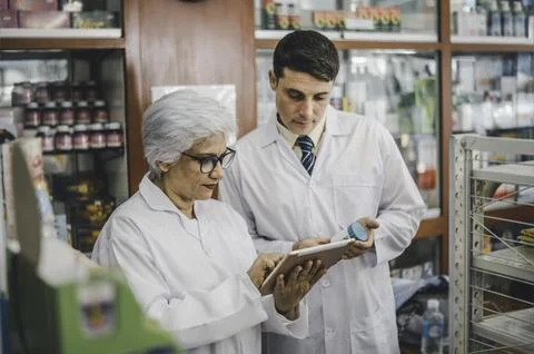 Skilled pharmacist is consulting, analyzing the use of drugs to recommend a.. Stock Photos